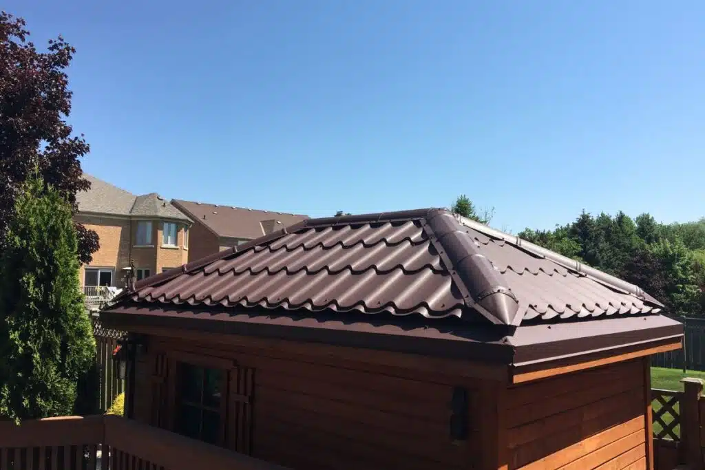 Close-up of a brown metal roof on a shed, showcasing the smooth and durable tiles under a bright blue sky in Richmond Hill.