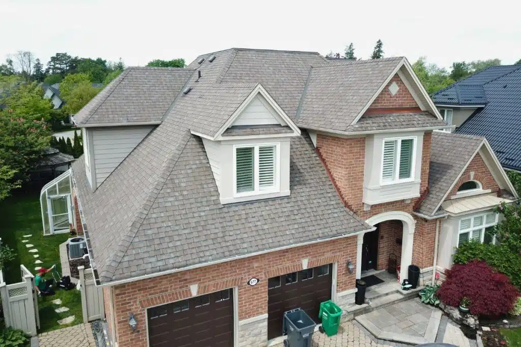 Before installation: the original shingle roof shows clear signs of aging, with wear visible across the surface of the roof.