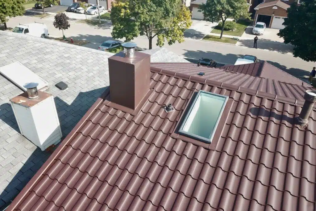 Brown Pural Adamante metal roof with a skylight and chimney, showcasing the roof's detailed design and clean integration.