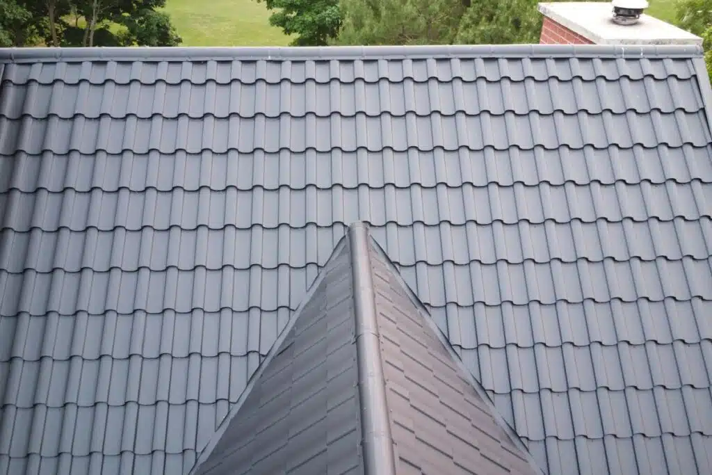 Top-down view of metal roof sections with a smooth dark finish, showcasing a seamless transition at the peak.