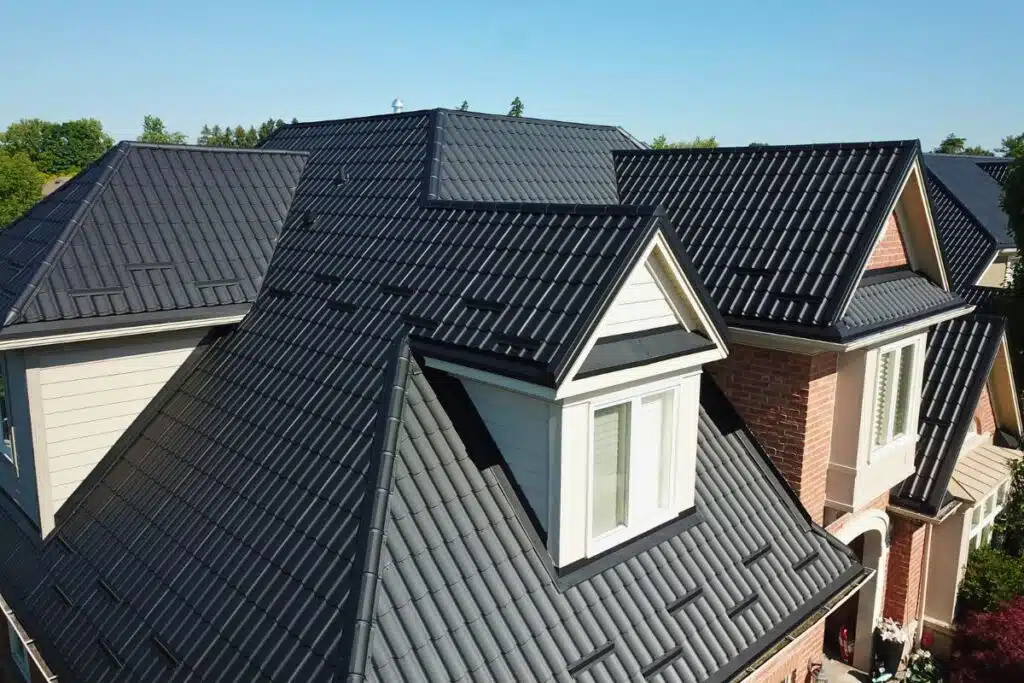 Newly installed metal roof with sleek black tiles, offering durability and an attractive finish, transforming the home's appearance.
