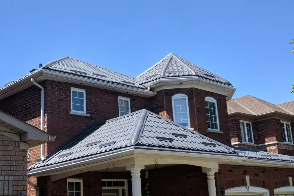 Newly installed metal roof on a residential house, showcasing dark gray panels and a sophisticated roof design.