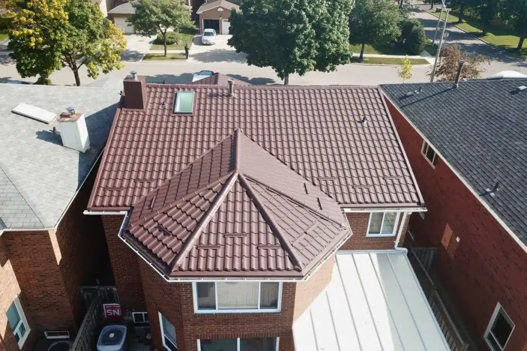 Top-down view of a finished brown metal roof with a skylight, highlighting its sleek design and well-integrated ventilation elements.