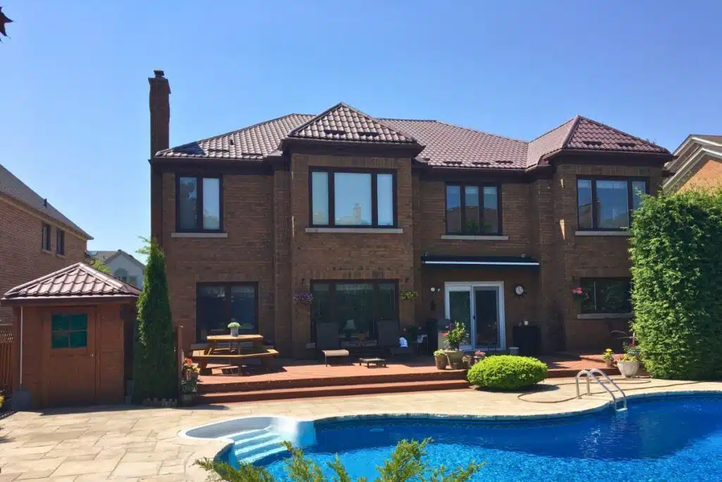 A residential house in Richmond Hill with a newly installed brown metal roof, featuring a pool and patio area.