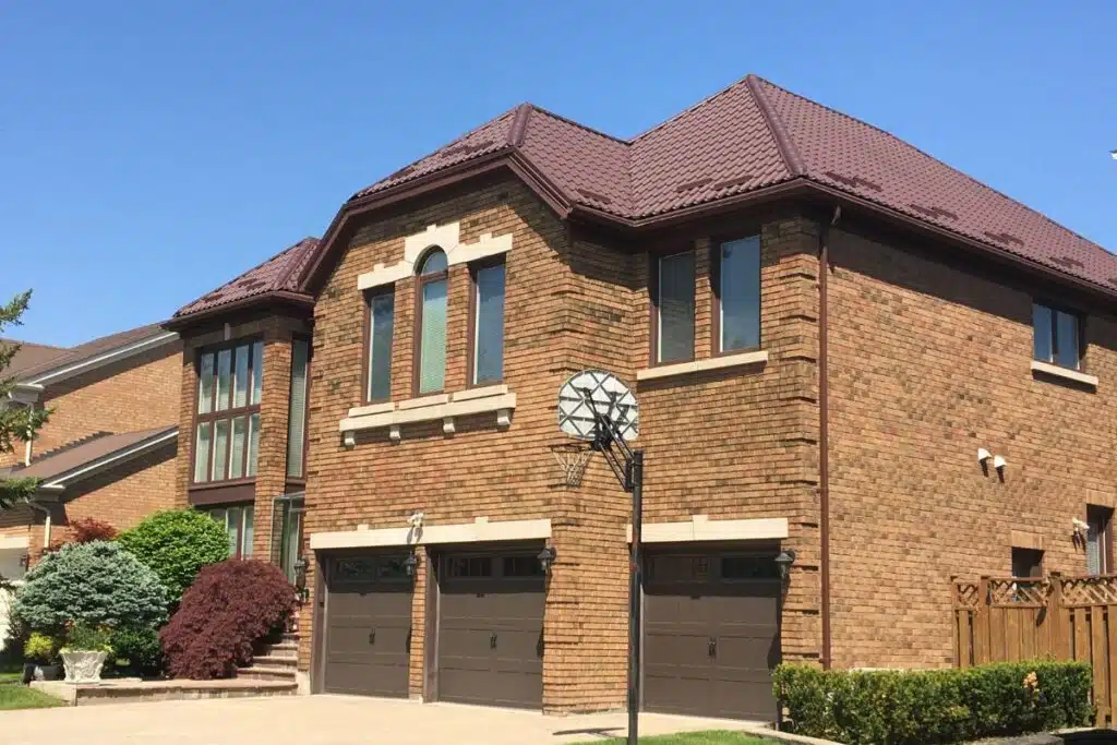 Exterior view of a house in Richmond Hill with a new brown metal roof installed, complementing the brick fasade.