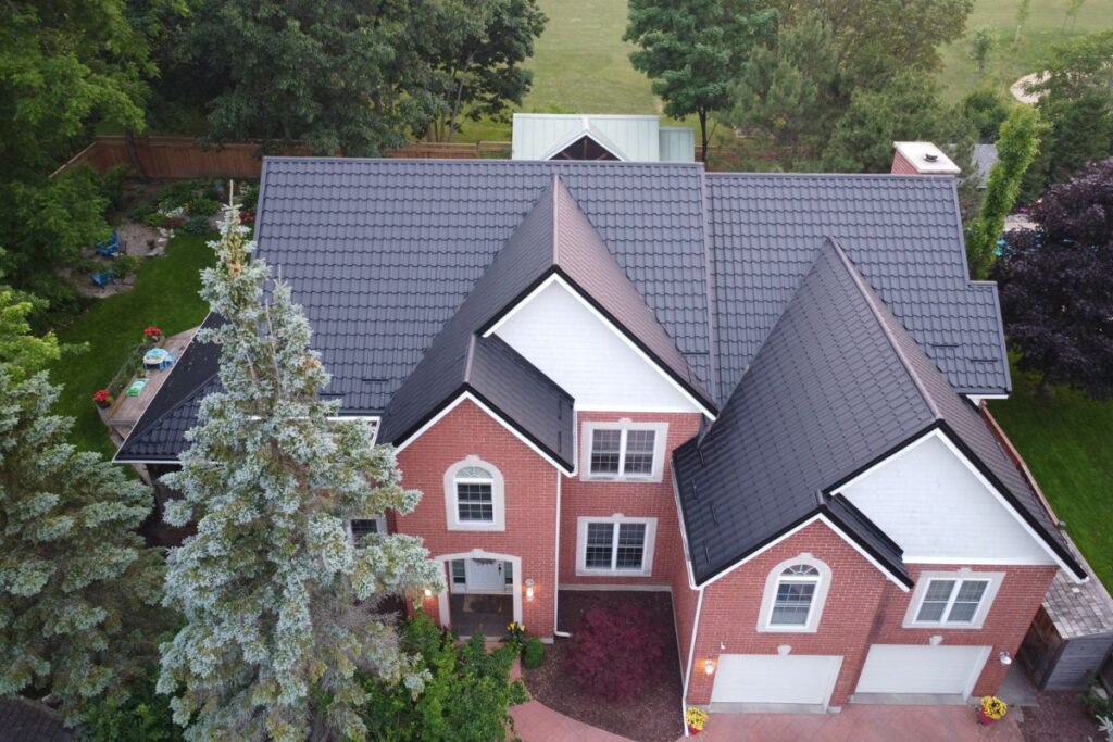 Aerial view of a neatly installed black metal tile roof, showcasing the clean lines and secure fit of the roofing tiles.