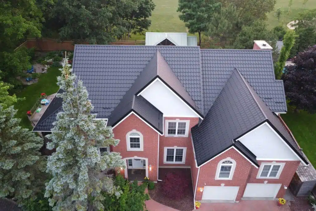 Aerial view of a neatly installed black metal tile roof, showcasing the clean lines and secure fit of the roofing tiles.