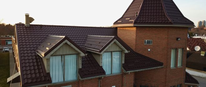 Red Tiled Roof with Turret and Large Windows Close-up view of a red-tiled roof with a distinctive turret and large windows.