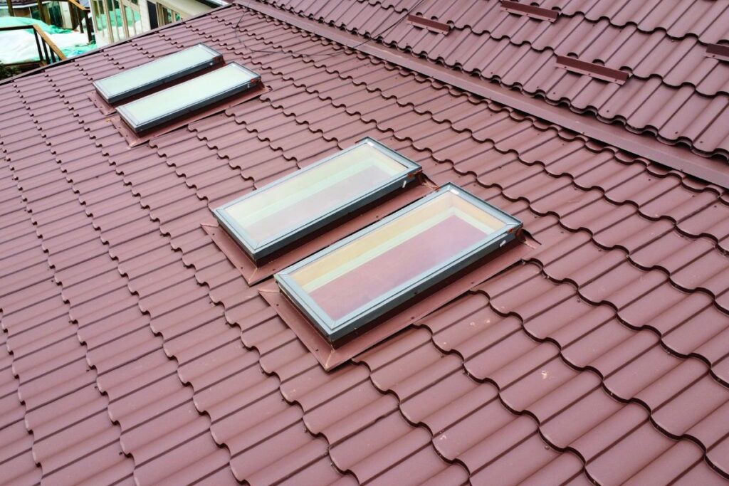 Close-up of chocolate brown metal tile roof with newly installed skylights.