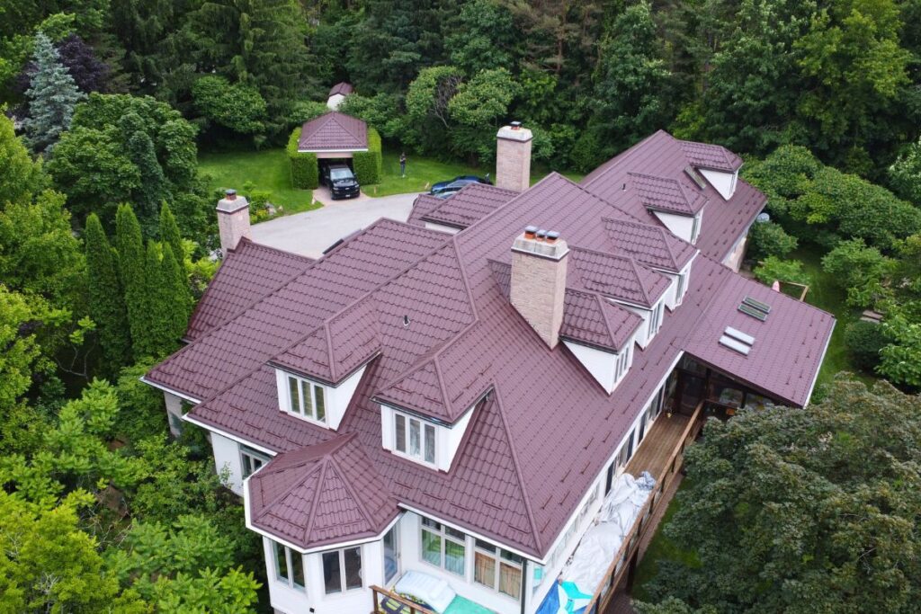 Aerial view of a large house with a newly installed brown metal tile roof.