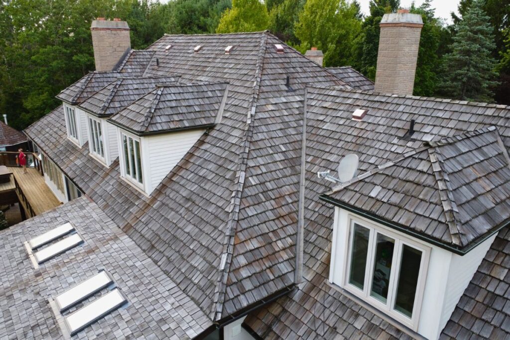 Old cedar roof with weathered shingles and skylights.