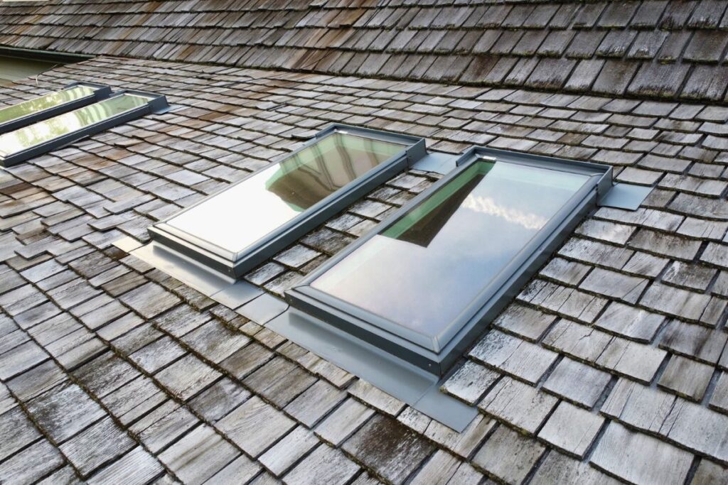 Old cedar roof with skylights before roof replacement begins.
