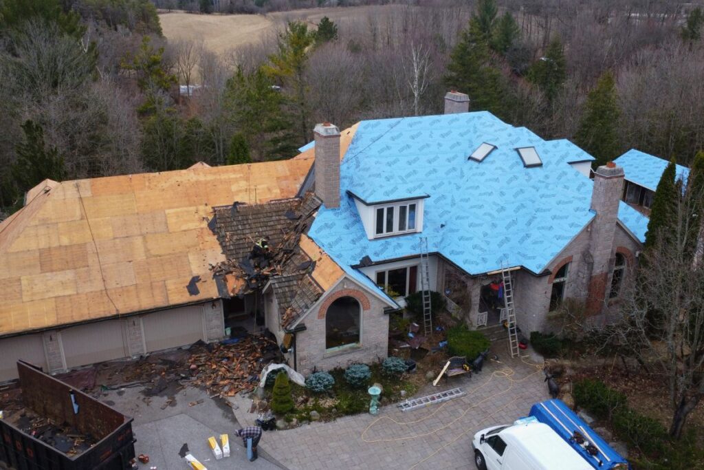 Roof replacement in progress, with old cedar shingles removed and waterproofing applied.