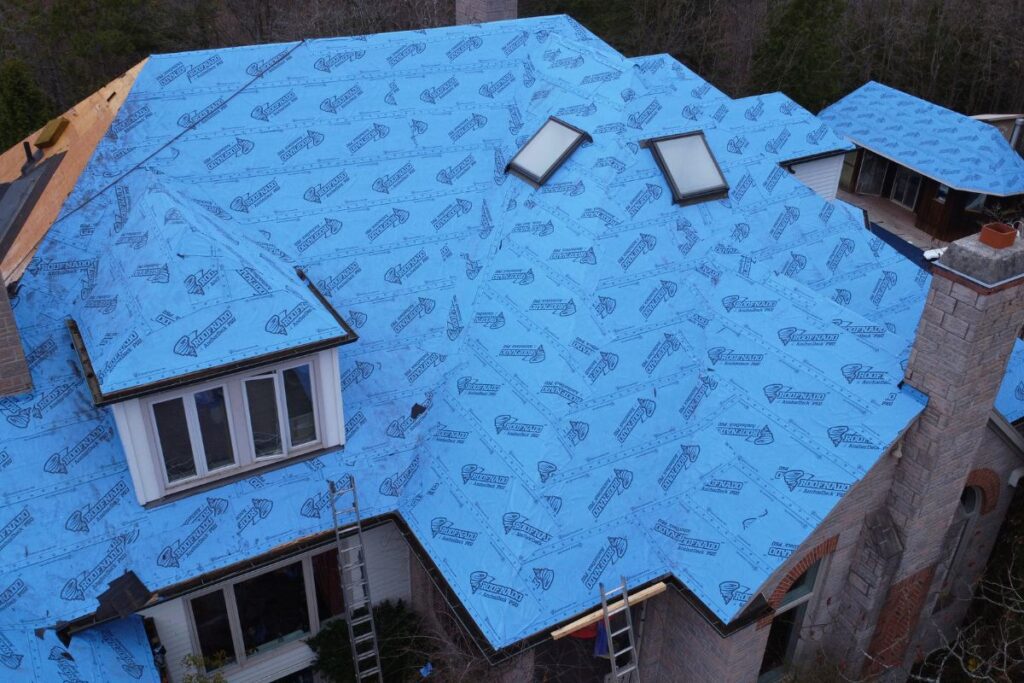 House roof prepared with blue waterproofing membrane and skylights.