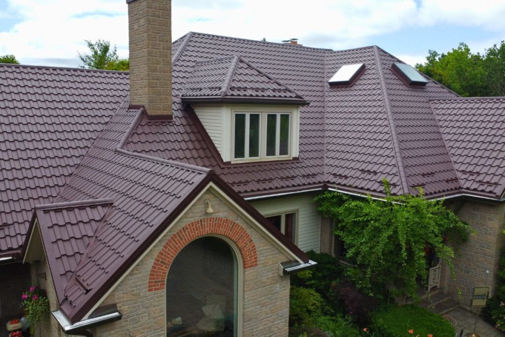 Close-up of a house with a chocolate brown metal tile roof and skylights.