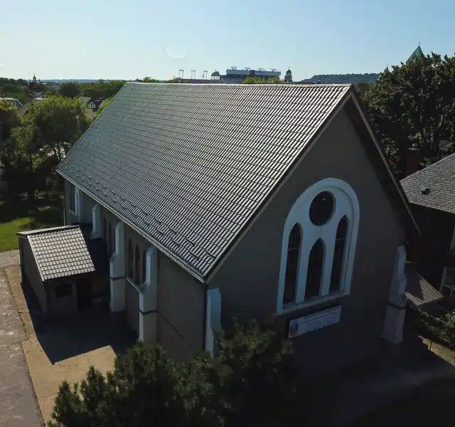 Large church building with durable black metal roofing.