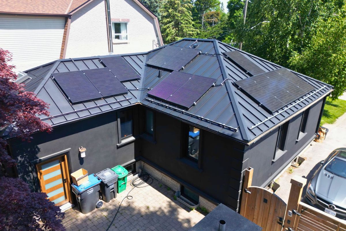 Full view of standing seam black metal roof with multiple solar panels in Mississauga