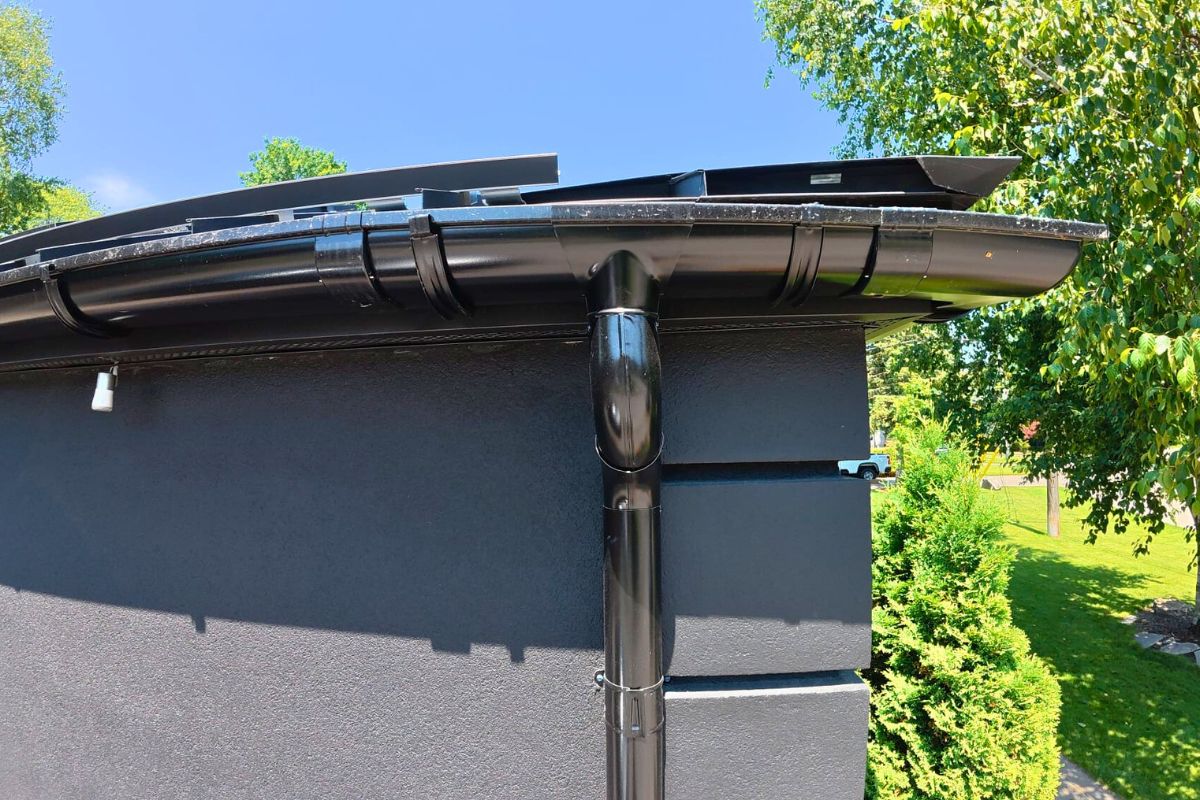 steel-gutter-downpipe Black steel gutter system with vertical downpipe on modern home in Mississauga