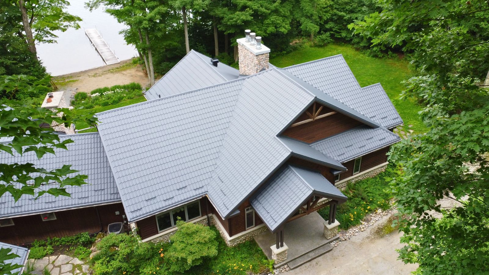 Aerial view of a metal tile roof with multiple slopes and individual snow guards on a Tiny Township home