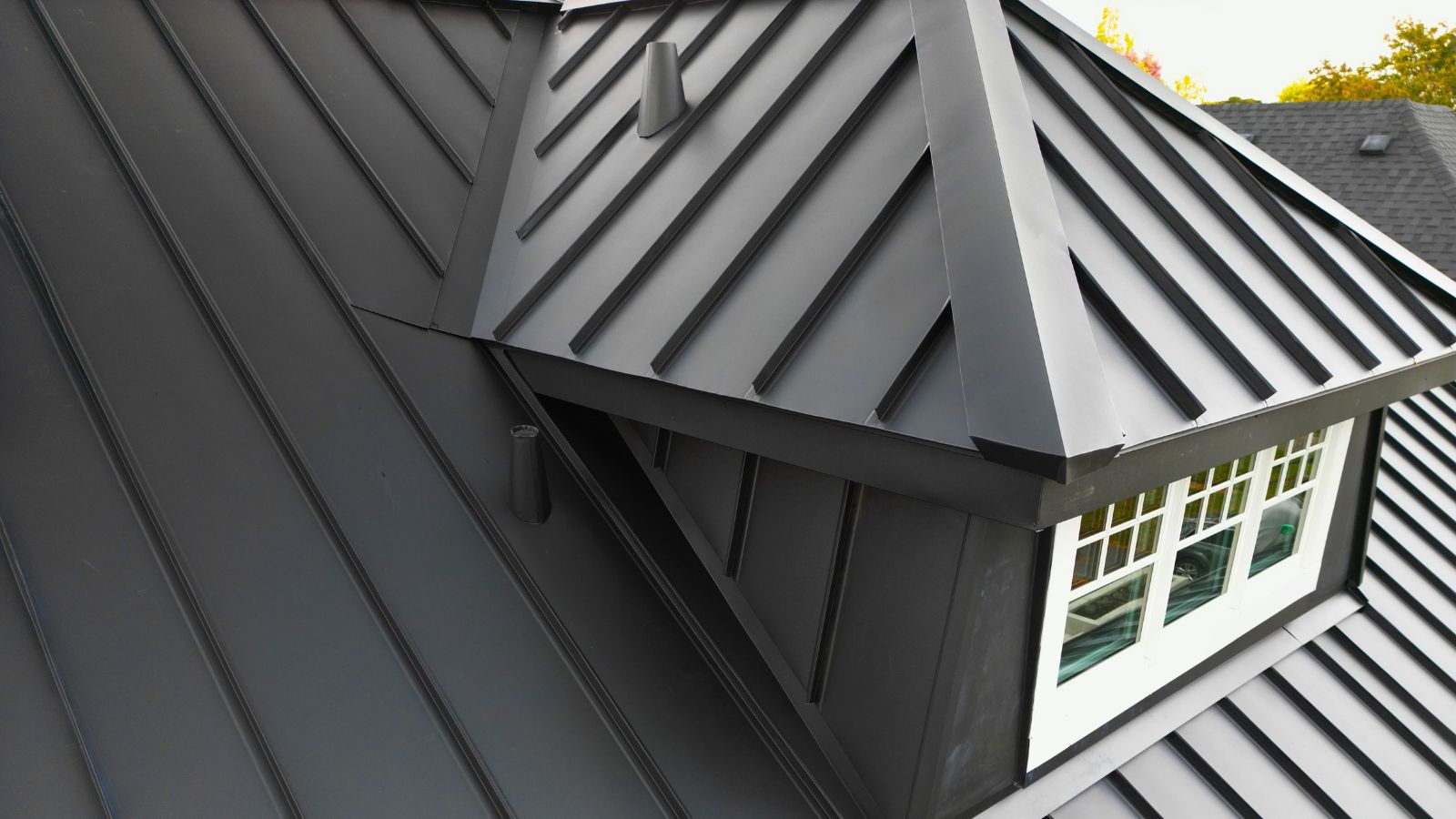 Close view of standing seam metal wall cladding and custom flashing around the front roof dormer