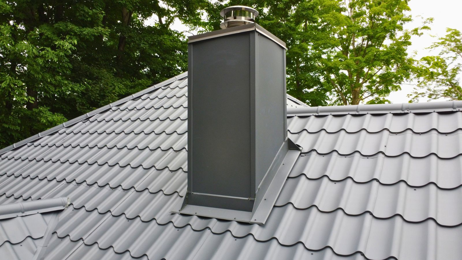Ruukki Monterrey metal tile roof with custom flashing around a metal chimney penetration