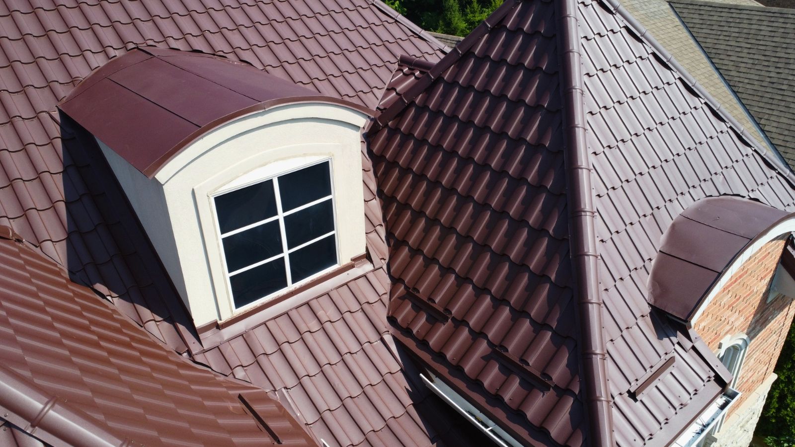 Metal tile roof detail around dormer, valley, hips, and curved roof sections