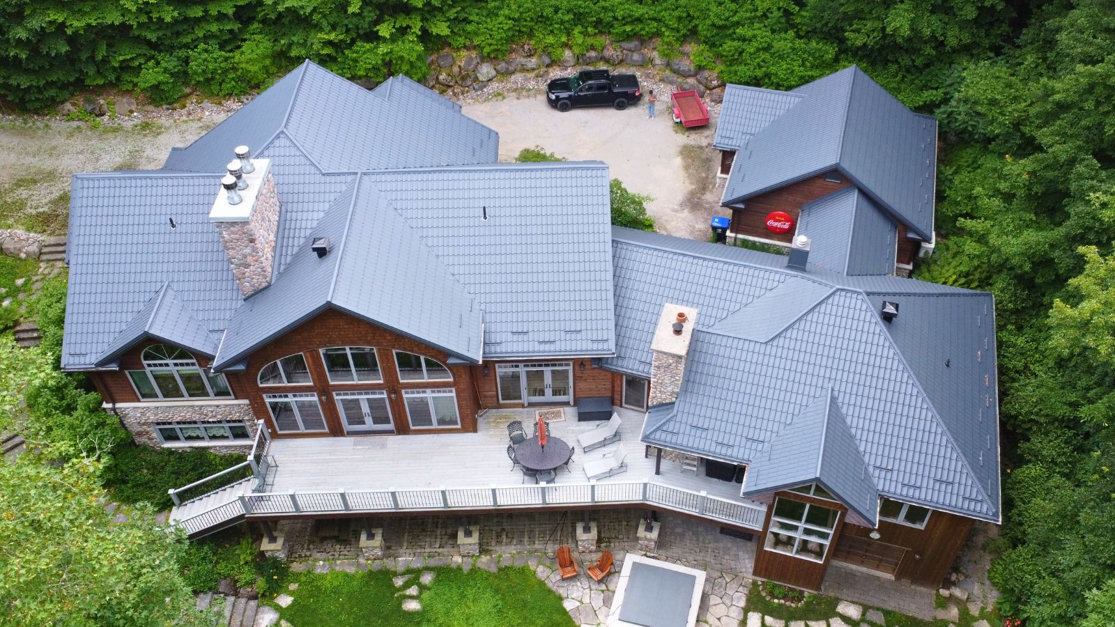 Metal Tile Roof in Tiny Township Full View Full aerial view of a RR22 Grey Ruukki Monterrey metal tile roof on a multi-slope residential home in Tiny Township