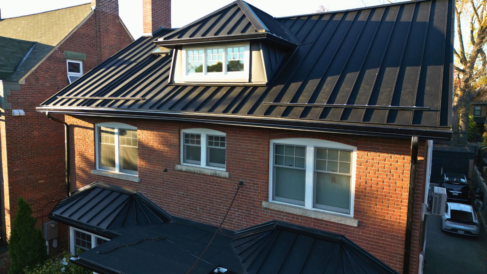 Century-old Toronto home in High Park with a Midnight Black standing seam roof, front dormer, and matching exterior details