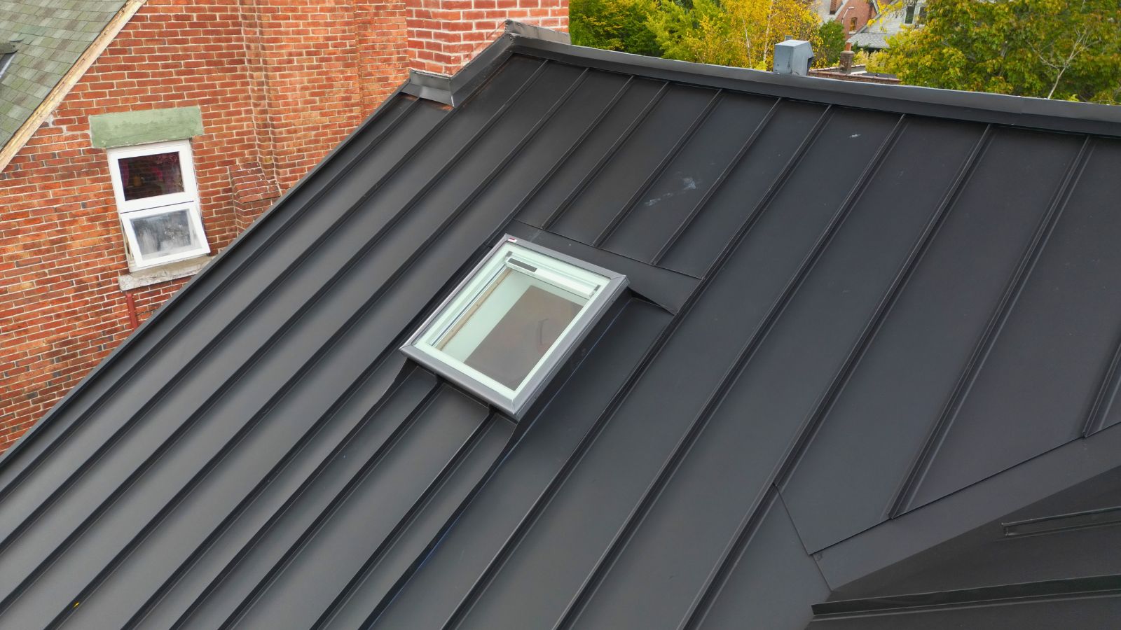 New VELUX skylight installed within a Midnight Black mechanical lock standing seam metal roof