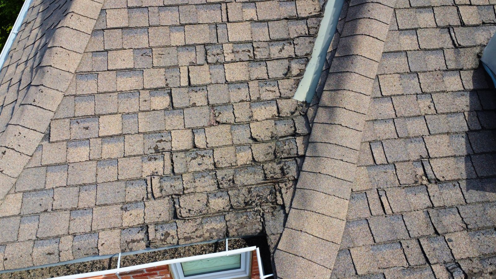 Close view of worn asphalt shingles before metal roofing installation