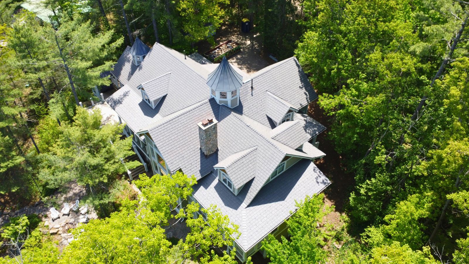 Aerial view of the main cottage with Enviroshake roofing and two standing seam cupolas in Muskoka