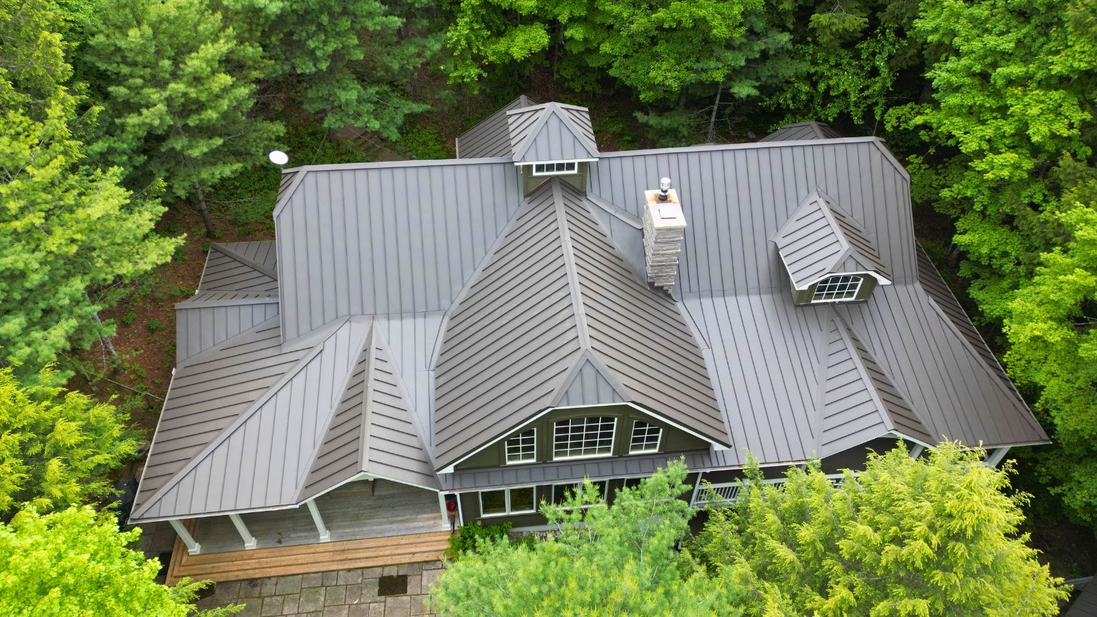 Aerial view of the completed Walnut Brown standing seam roof on a cottage in Huntsville, Muskoka